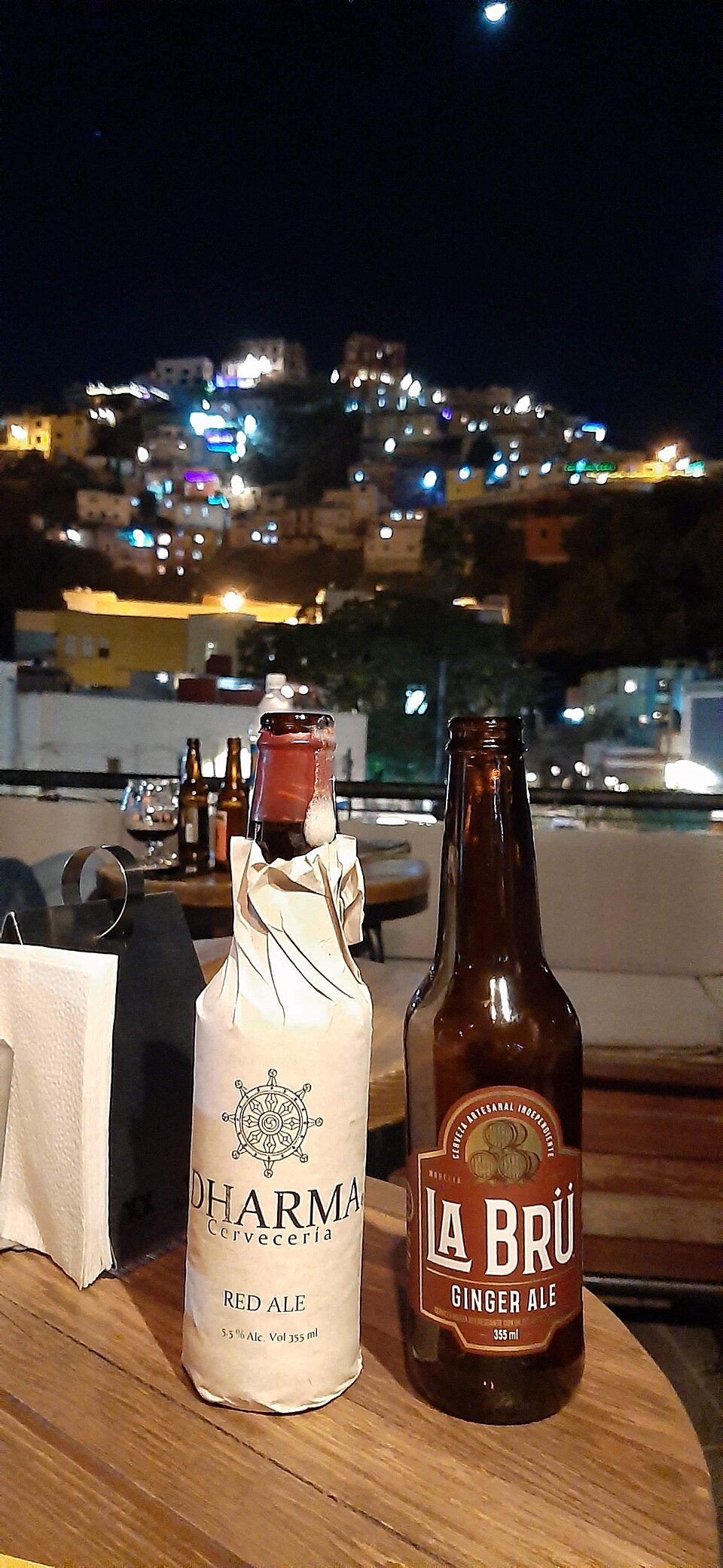 Real photograph of craft beer bottles with evening city lights